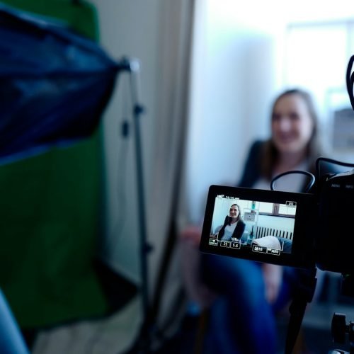 a woman sitting in front of a green screen